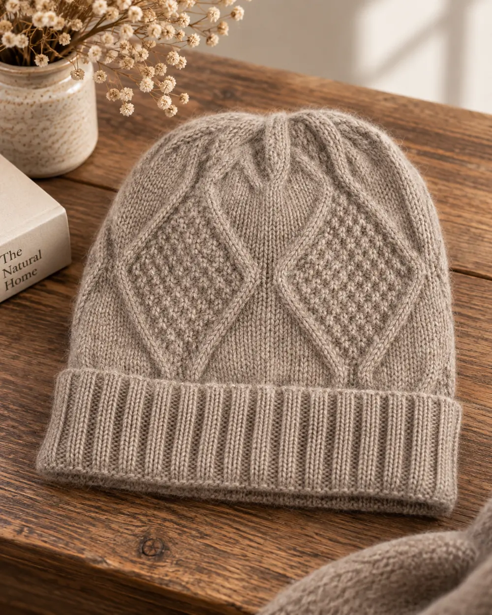 Eine gestrickte Qiviut-Mütze auf einem Holztisch.